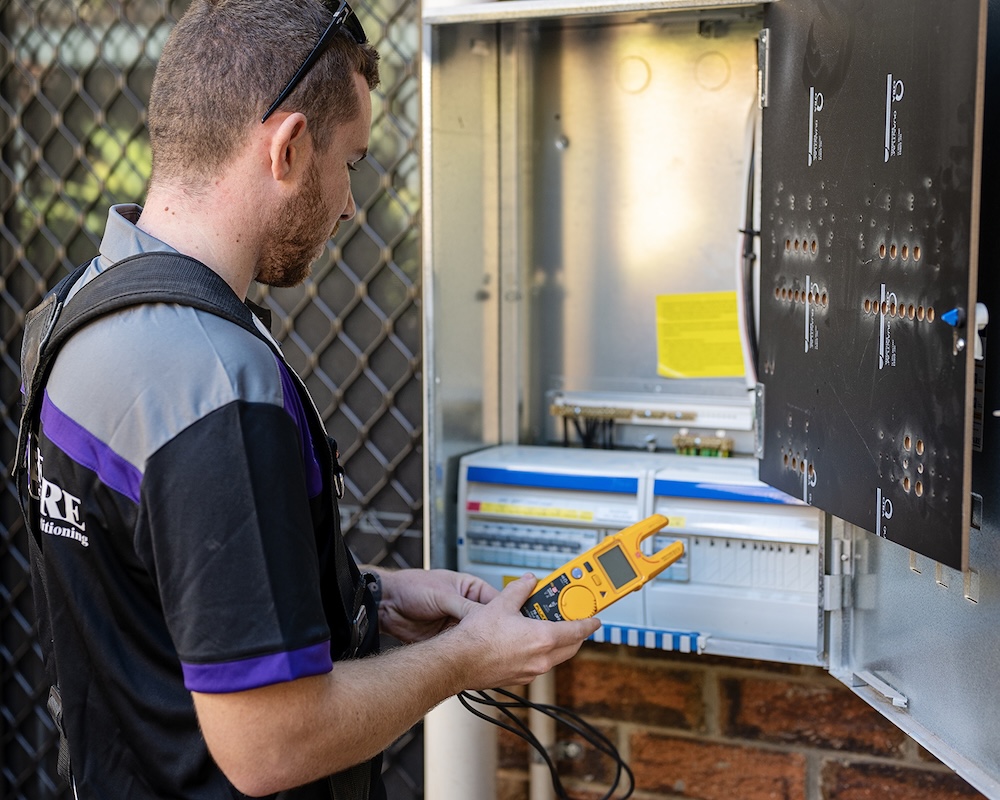 electrician inspecting a residential switchboard for faults