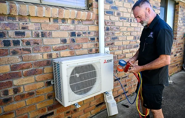 Electrician performing a switchboard upgrade Loganholme, installing new safety switches and labelled circuit breakers in a modern board.