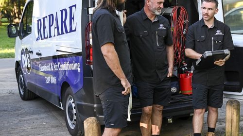 Emergency electrician Loganholme inspecting a switchboard, testing a tripping safety switch and checking for heat damaged connections.