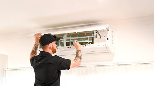 Surge protection Loganholme, electrician installing a surge protection device inside a modern switchboard with labelled breakers.