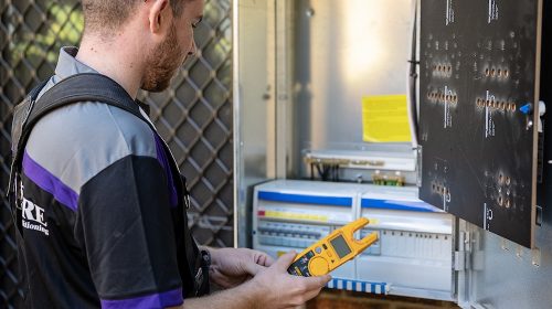 electrician inspecting a residential switchboard for faults